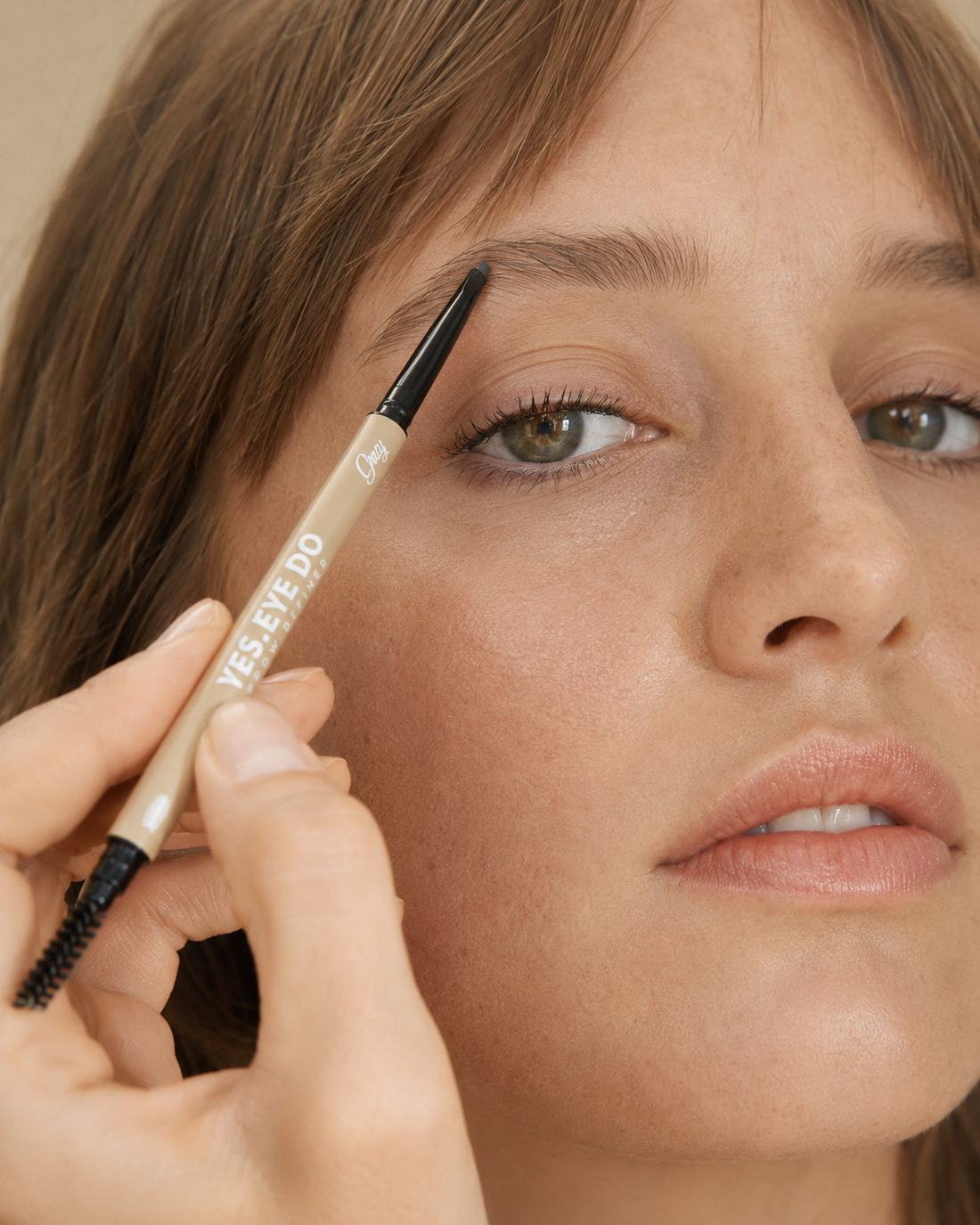 Model filling the tail of her brow with the Grey Micro Brow Pencil