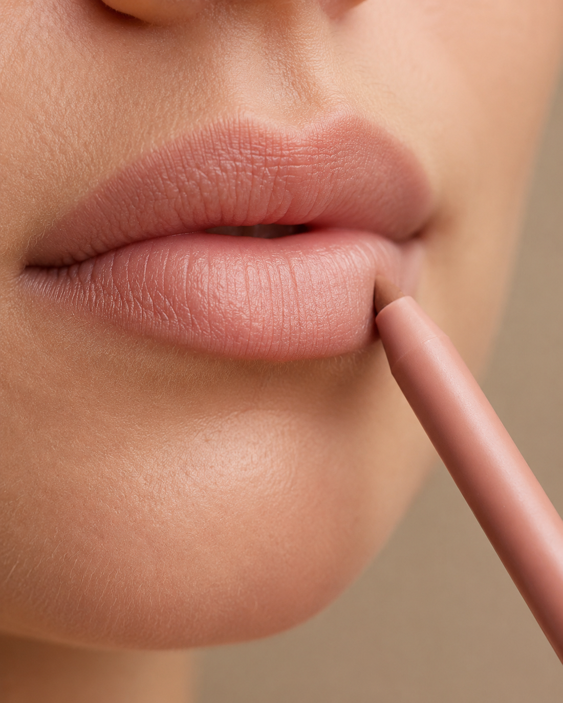 Close-up of nude lip liner drawing along the lower lip edge