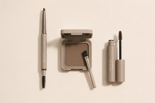 Brow pencil, pressed brow powder with brush, and brow gel tube laid side by side