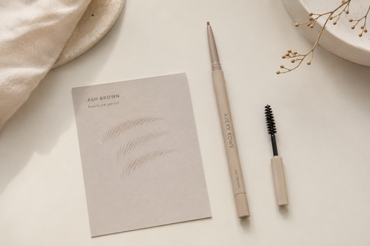 Fine brow pencil with spoolie beside a card of hair-like brow strokes
