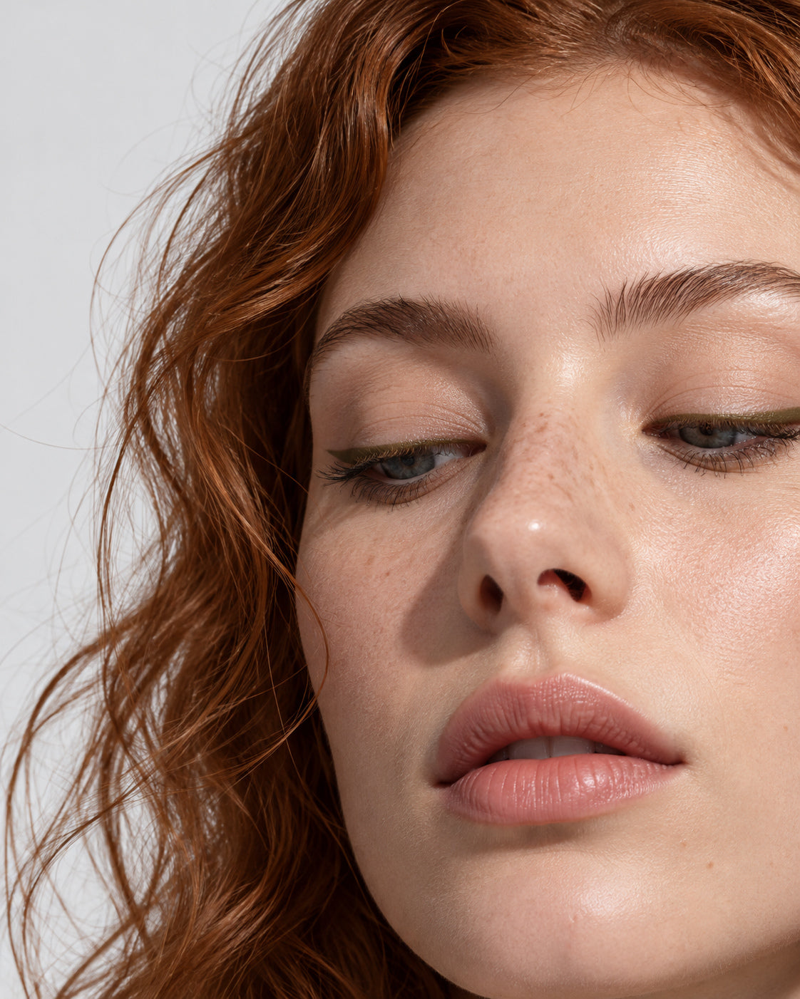 Close-up look with a soft olive-brown eyeliner line along the upper lash line