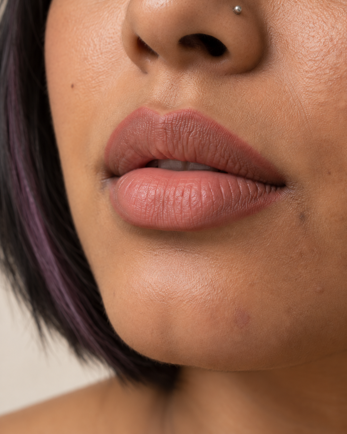 Close-up of lips lined in a rosy nude tone