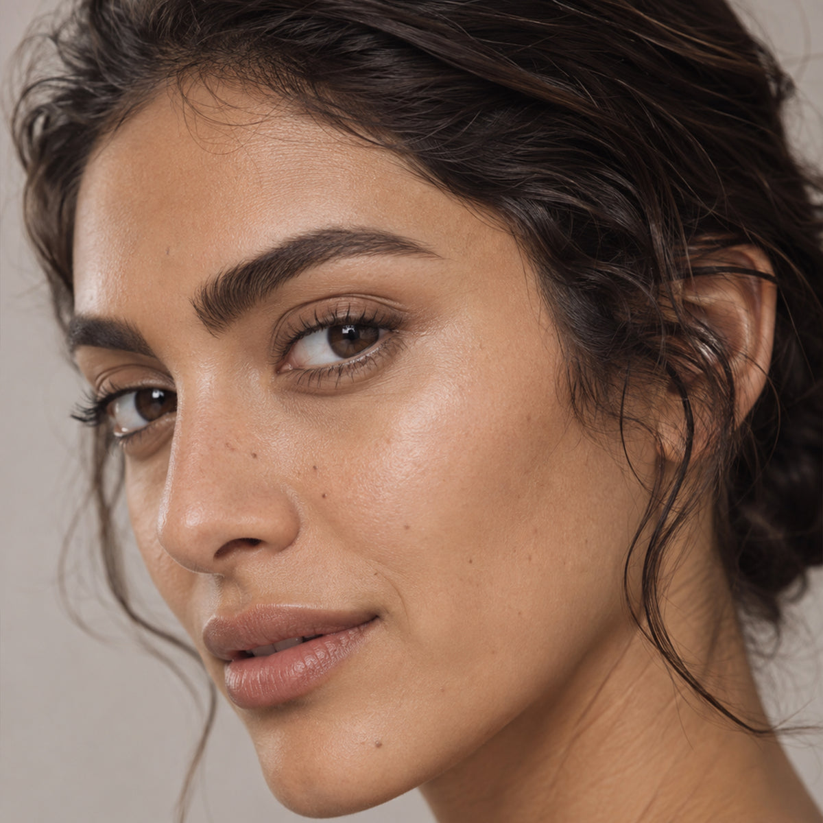 Model with softly filled grey-taupe brows on light skin