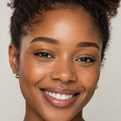 Smiling model with warm brown pomade brows on medium skin