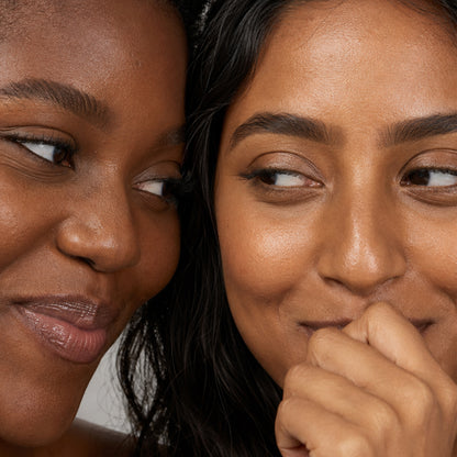 Close-up of a softly defined brown brow on tan skin, smiling model